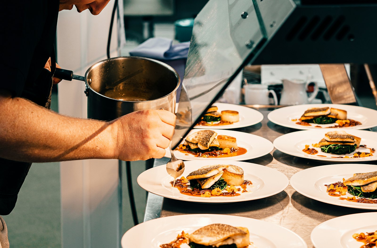 Un chef qui dresse un plat dans la cuisine d'un restaurant